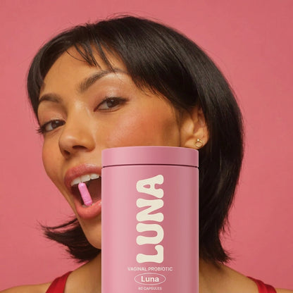 Woman taking a Luna vaginal probiotic capsule